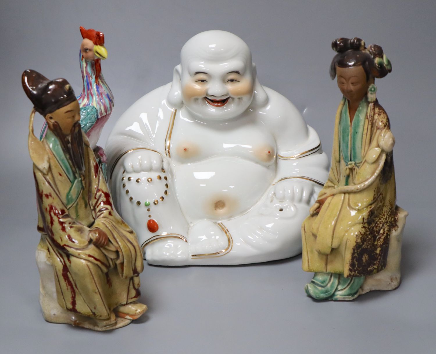 Four Chinese ceramic figures including Budai, 23cm, an enamelled phoenix, 24cm and two Chinese earthenware seated figures